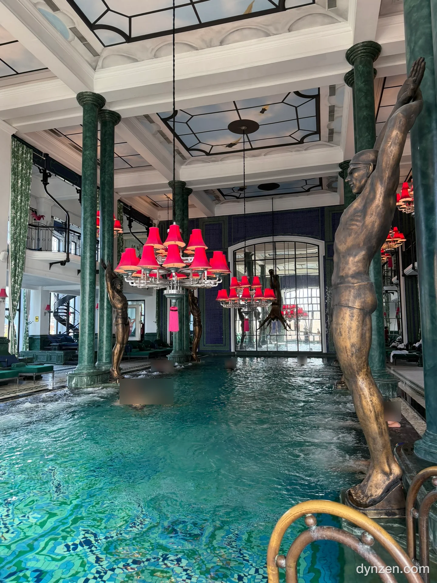 The hotel’s indoor pool with red chandeliers, green marble columns and statues