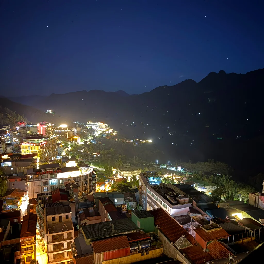 Sapa at night seen from the hotel’s 10th-floor terrace, the lit-up town with a dark mountain ridge behind it