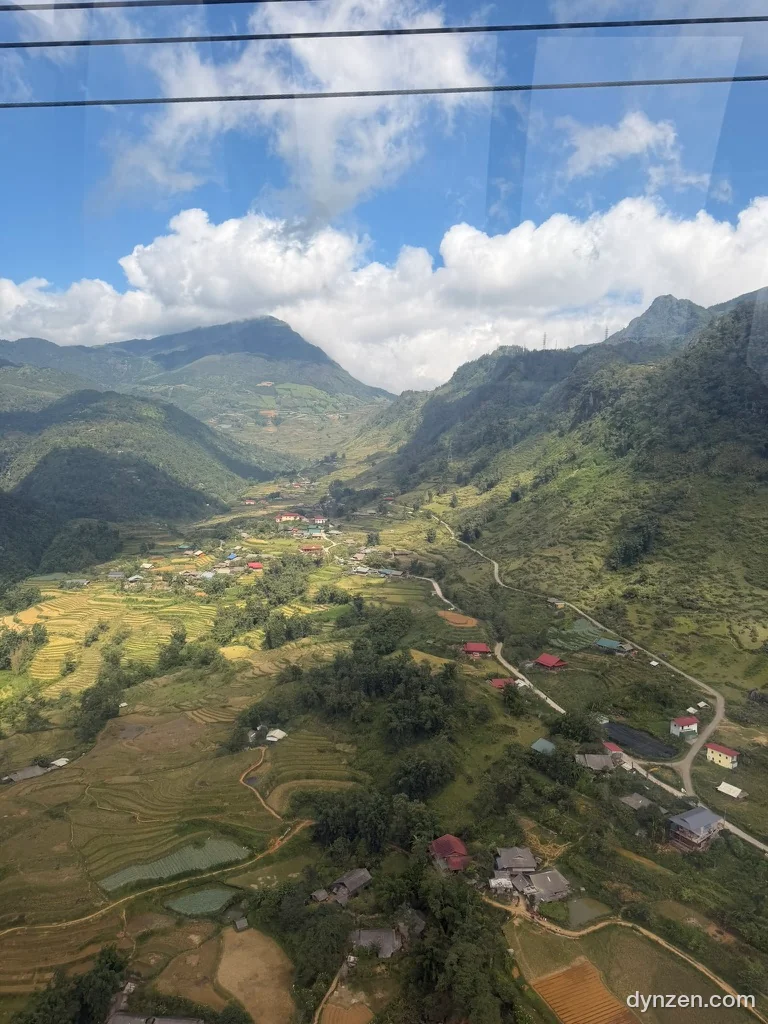 Out the cable car window, terraced rice fields and a small village in a valley along the mountainside
