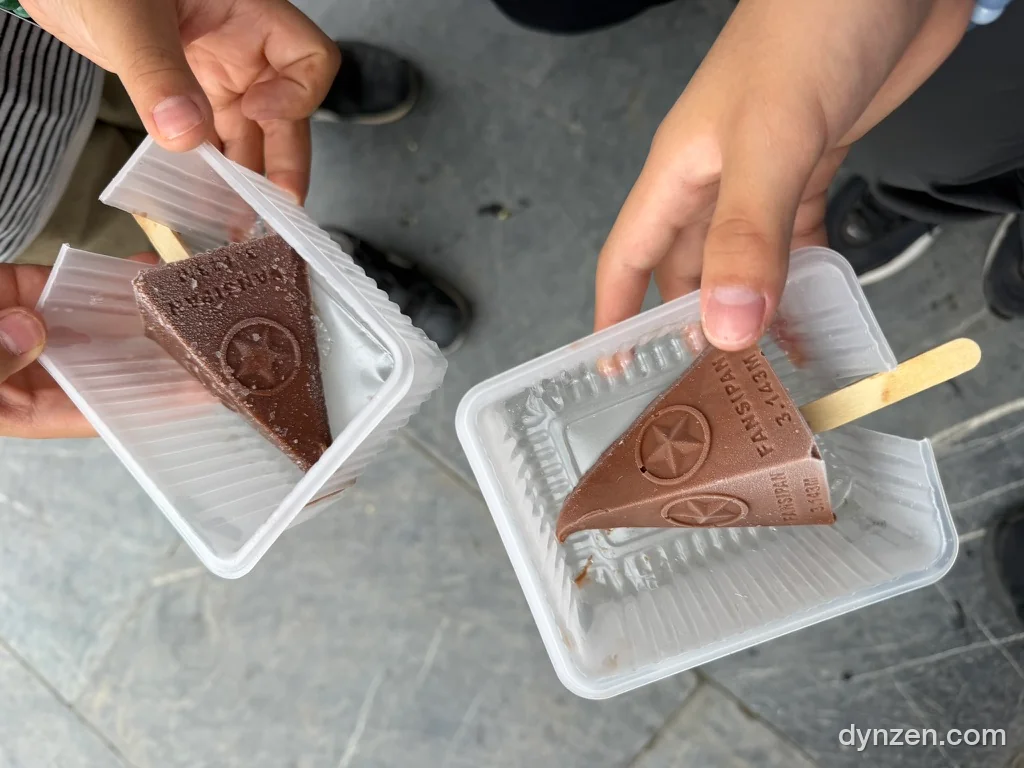 Two kids each holding a triangular ice cream engraved ‘FANSIPAN 3.143M’