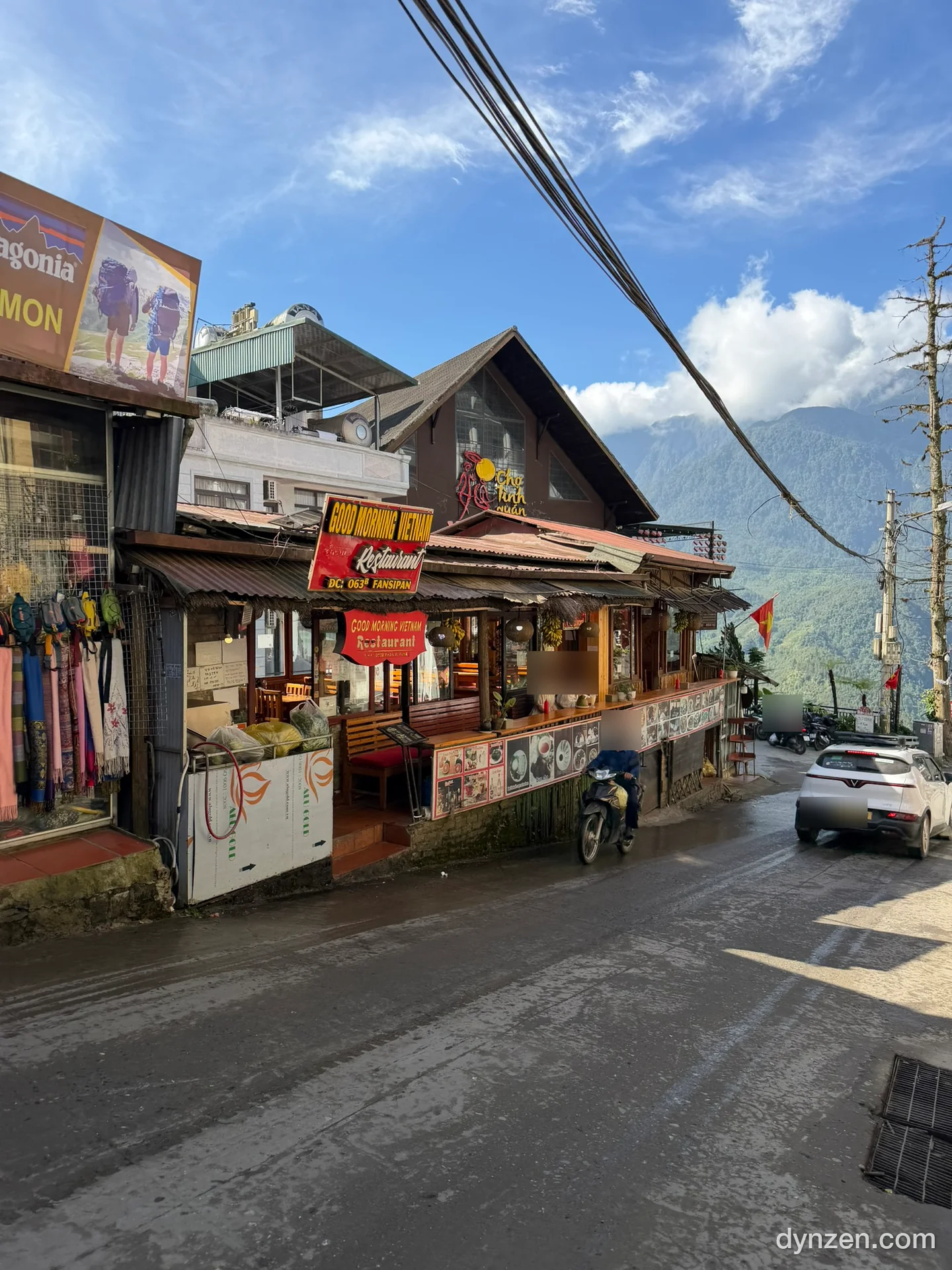 The exterior of Good Morning Vietnam, a ‘GOOD MORNING VIETNAM Restaurant’ sign with a green mountain behind it