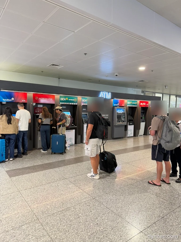 The row of ATMs in the Noi Bai arrivals hall, Agribank, BIDV and others side by side