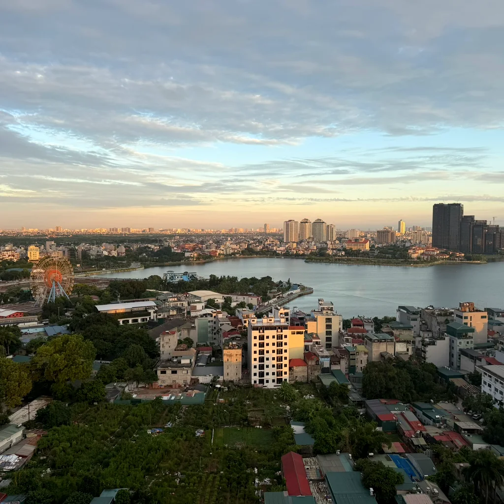The view of West Lake from the window of our L7 West Lake room, a Ferris wheel on the left and sunset colors spreading above the horizon