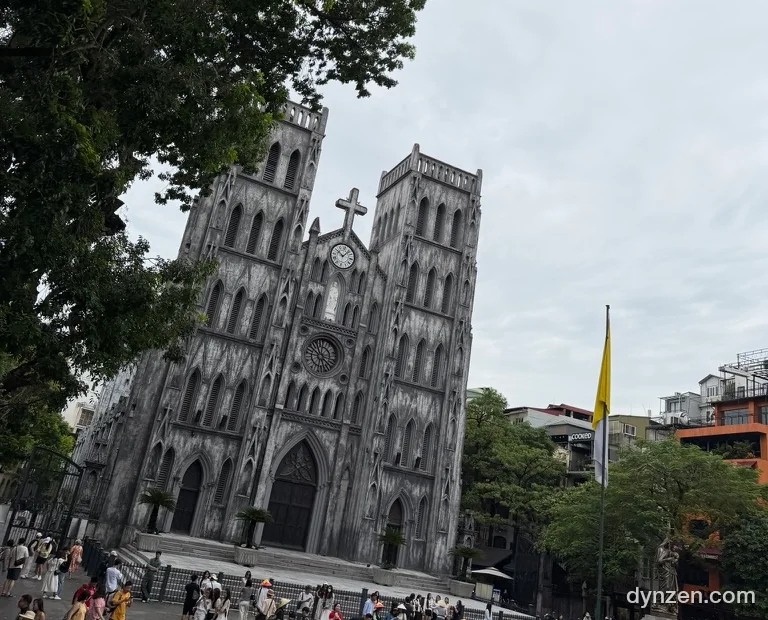 St. Joseph’s Cathedral in Hanoi seen from the city tour bus, Gothic twin spires and tourists in the square in front