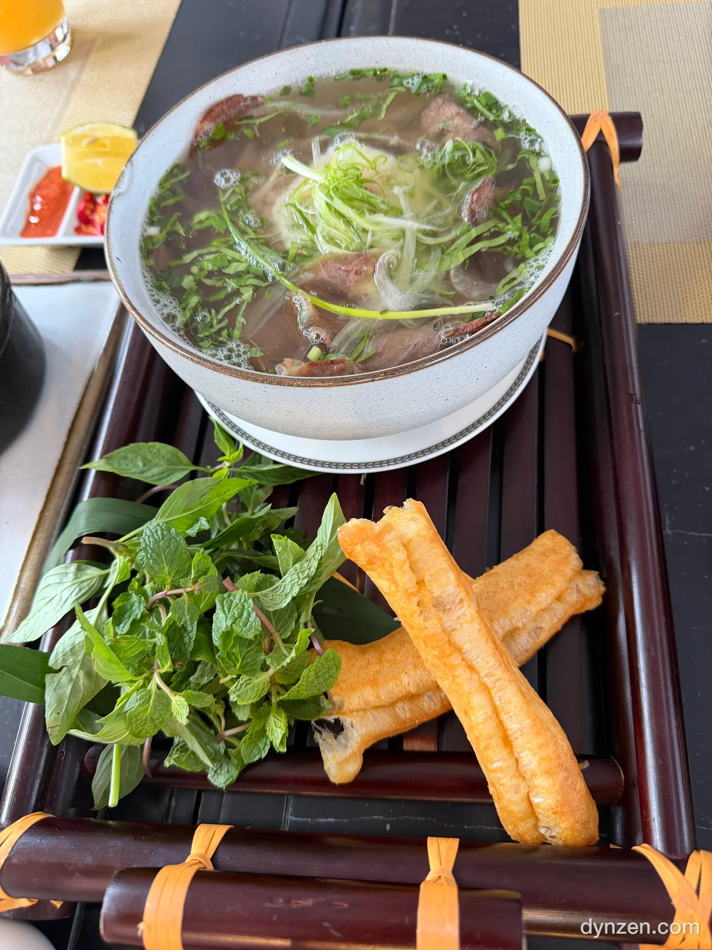 와규 쌀국수, 맑은 국물 위 얇게 썬 소고기와 파채, 옆에 허브 한 줌과 꽈배기 튀김