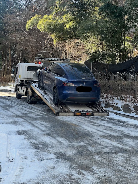 Tesla Model Y being loaded onto a tow truck